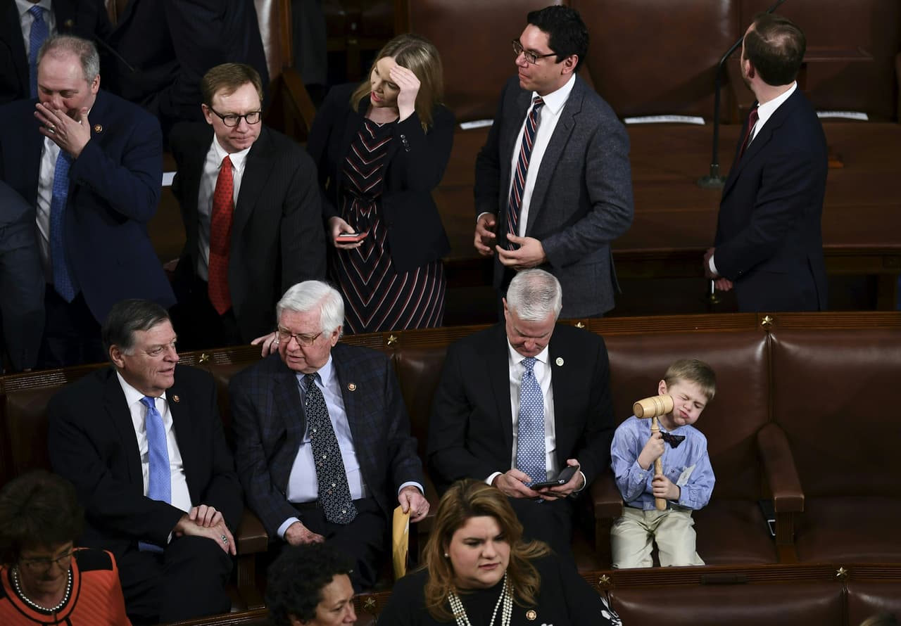 Un niño juega con el martillo utilizado para controlar las sesiones de la Cámara minutos antes del comienzo de la primera sesión.