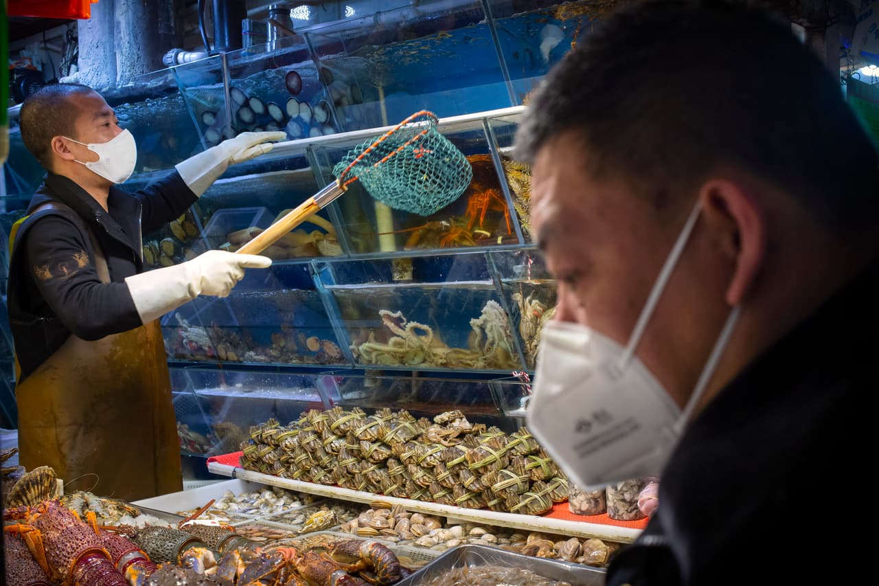 Residentes de Pekín hacen compras en un mercado de la ciudad, el 14 de marzo de 2020. En esta ciudad se han endurecido las medidas para evitar la llegadas internacionales. Las autoridades aseguran que muchos de los casos nuevos provienen de otros países afectados.