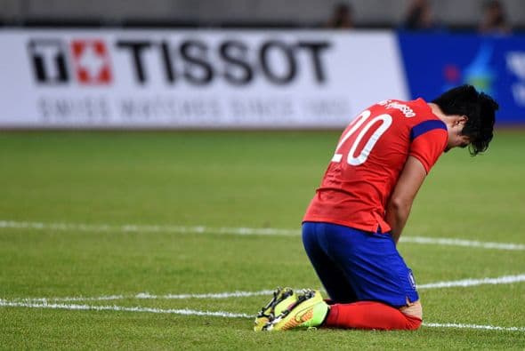 Jang Hyunsoo de Corea del Sur ora para celebrar la victoria sobre Japón después del pitido final durante el partido de cuartos de final de fútbol entre Corea del Sur y Japón en el Estadio Munhak, durante los Juegos Asiáticos de 2014.