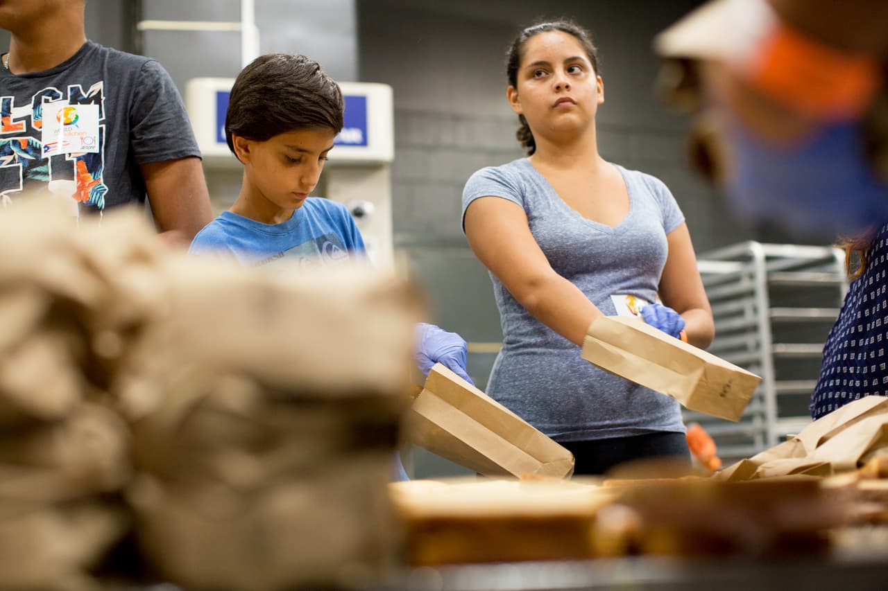 Niños y adultos preparon y empacaron cientos de sándwiches. La orden era organizarlos en grupos de 60 en cajas que luego son repartidas a quienes llegan al coliseo o con el apoyo de food trucks que van recorriendo la isla.