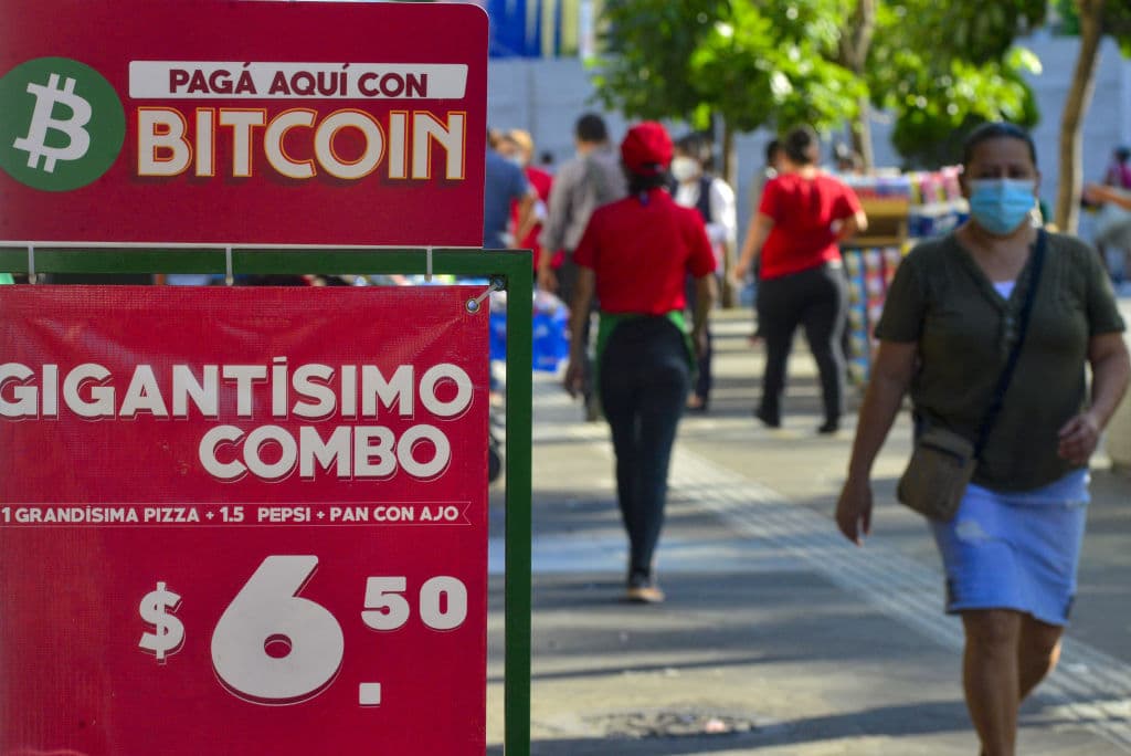 Un cartel muestra la moneda Bitcoin como método de pago en un local de comida rápida el 21 de octubre de 2021 en San Salvador, Departamento de San Salvador, El Salvador.