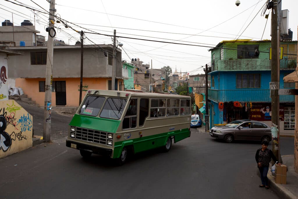 En esta fotografía del 15 de mayo de 2019, un camión del transporte público pasa por el vecindario de San Miguel Teotongo, en la Ciudad de México. (AP Foto/Rebecca Blackwell)