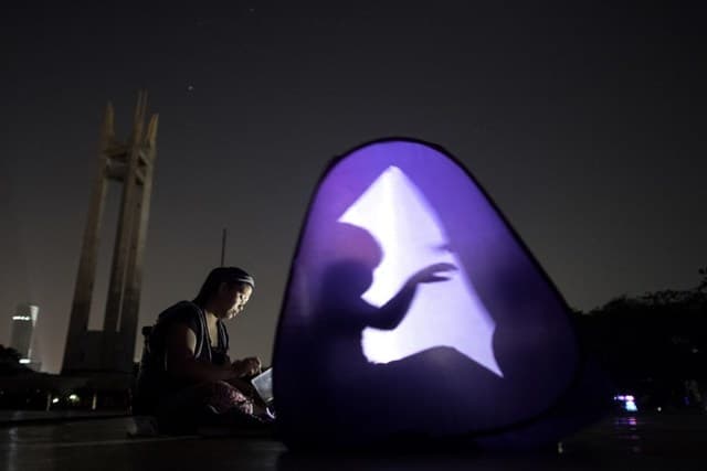 Una persona juega con su sombra en Filipinas en medio de la oscuridad al marcarse la "Hora de la tierra".