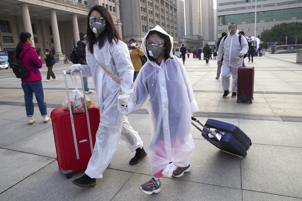 Pasejors usan mascarillas y trajes protectores a las afueras de la estación de tren Hankou, en Wuhan, China este miércoles 8 de abril.