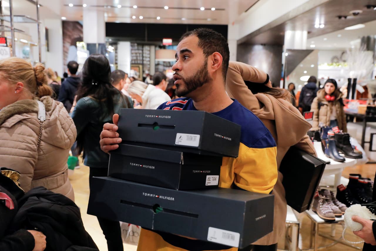 En Estados Unidos, la 'locura' de las compras se percibía desde la mañana en lugares como la ciudad de Nueva York. En la imagen, un empleado de la tienda Macy's en Herald Square lleva varias cajas con zapatos durante el 'Viernes negro'. 
<br>