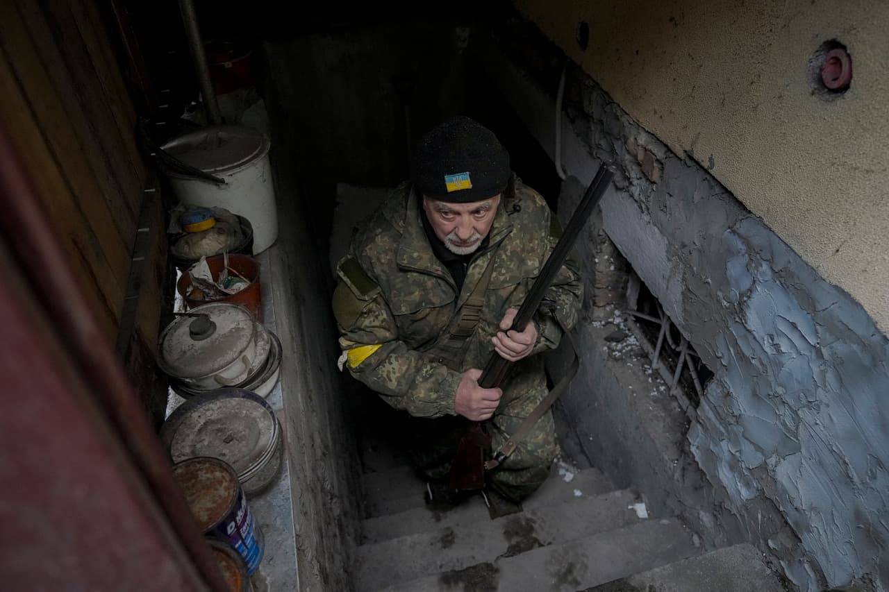 Andrey Goncharuk tiene 68 años y es miembro de la defensa territorial ucraniana. La fotografía lo muestra saliendo del pequeño sótano de una casa que está lleno personas en Gorenka, a las afueras de Kiev. 2 de marzo.
<br>