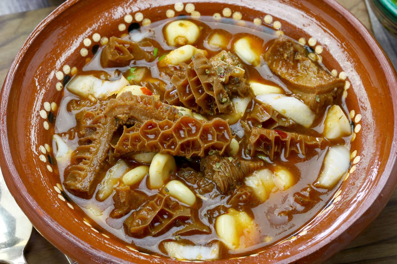 <b>Menudo</b>
<br>
<br>
<b>Origen: México</b>
<br>
<br>Este plato a base de callos cocidos a fuego lento es el favorito de muchos en bodas y grandes eventos, y tiene fama de ser un buen remedio para la resaca.
<br>
<br>Es pura comida reconfortante, incluye granos de maíz y una guarnición de cebollas crudas, chiles y cilantro.
<br>
<br>Las dos variedades más populares son el Menudo Rojo, que toma un color intenso de los chiles en el caldo, y el Menudo blanco, al estilo de Sonora, una alternativa menos picante.
<br>