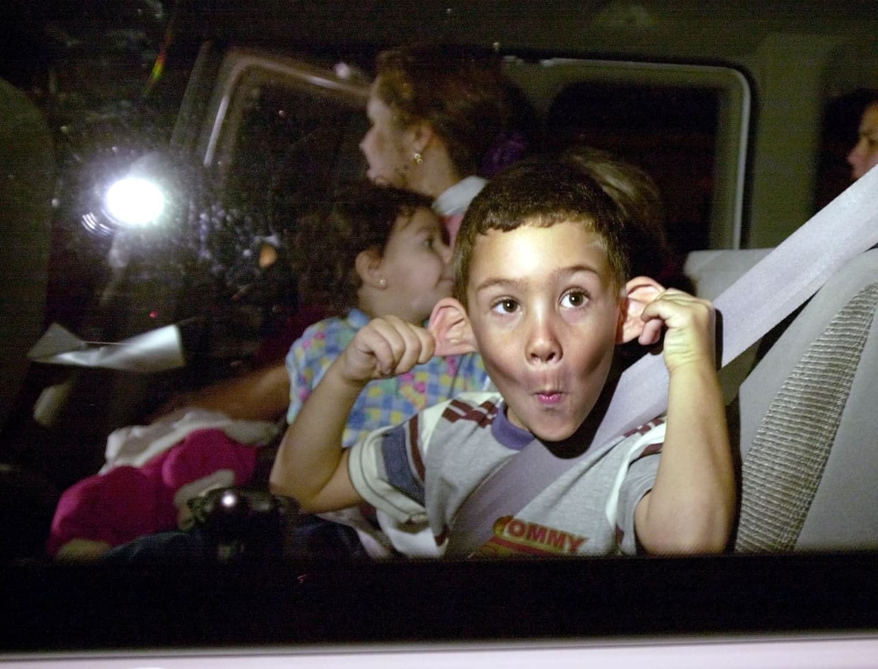 Elián hace muecas a los reporteros gráficos apostados frente a la casa de sus tíos en Pequeña Habana, en Miami.