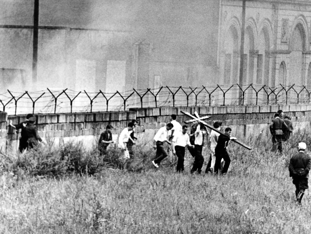 Jóvenes de Berlín occidental son reprimidos por guardias de Alemania oriental con gas lacrimógeno en las cercanías del muro. Intentaban protestar por el primer aniversario de su construcción, el 13 de agosto de 1962.