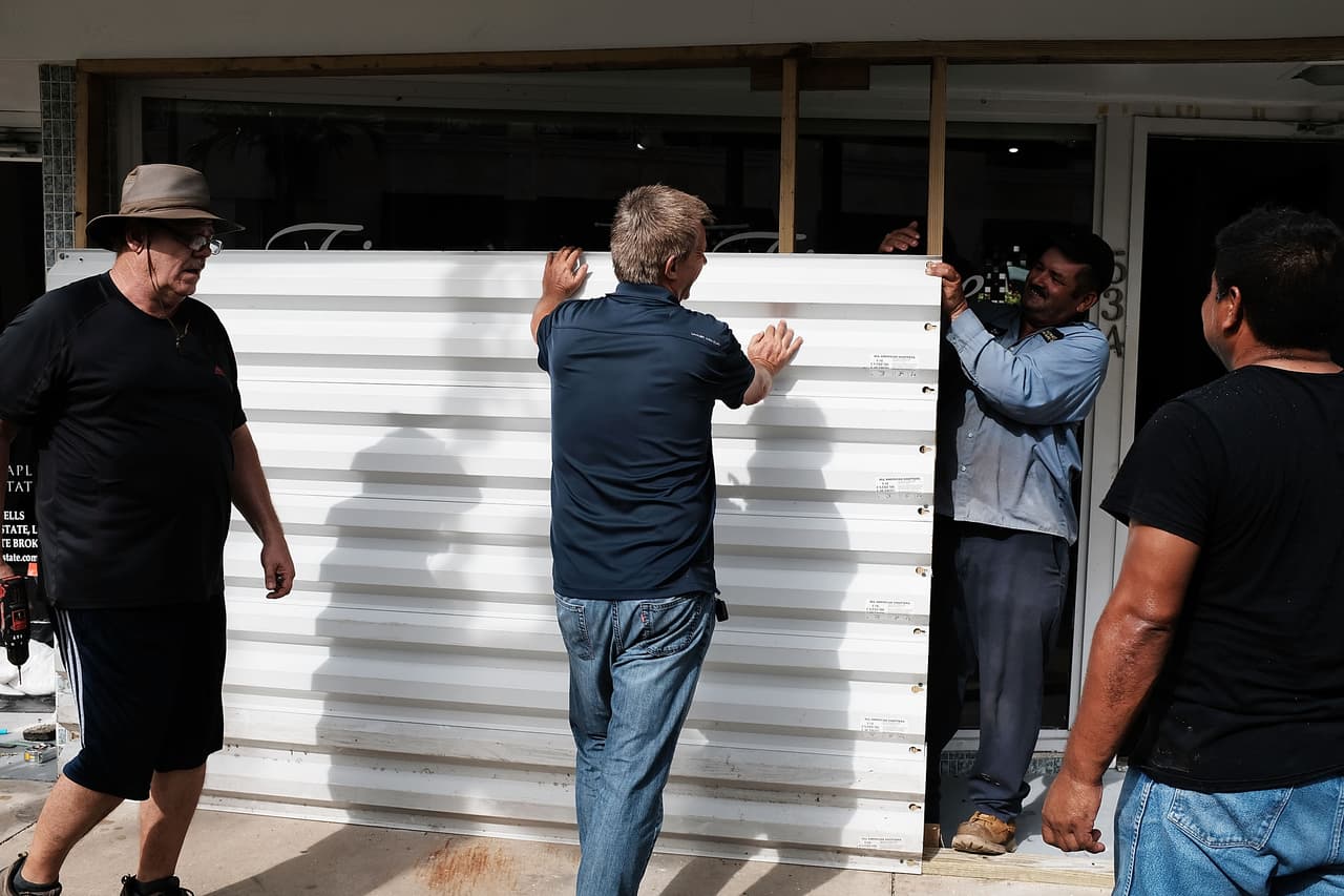 Men put metal sheets on the front of a business in downtown Naples before the arrival of Hurricane Irma.