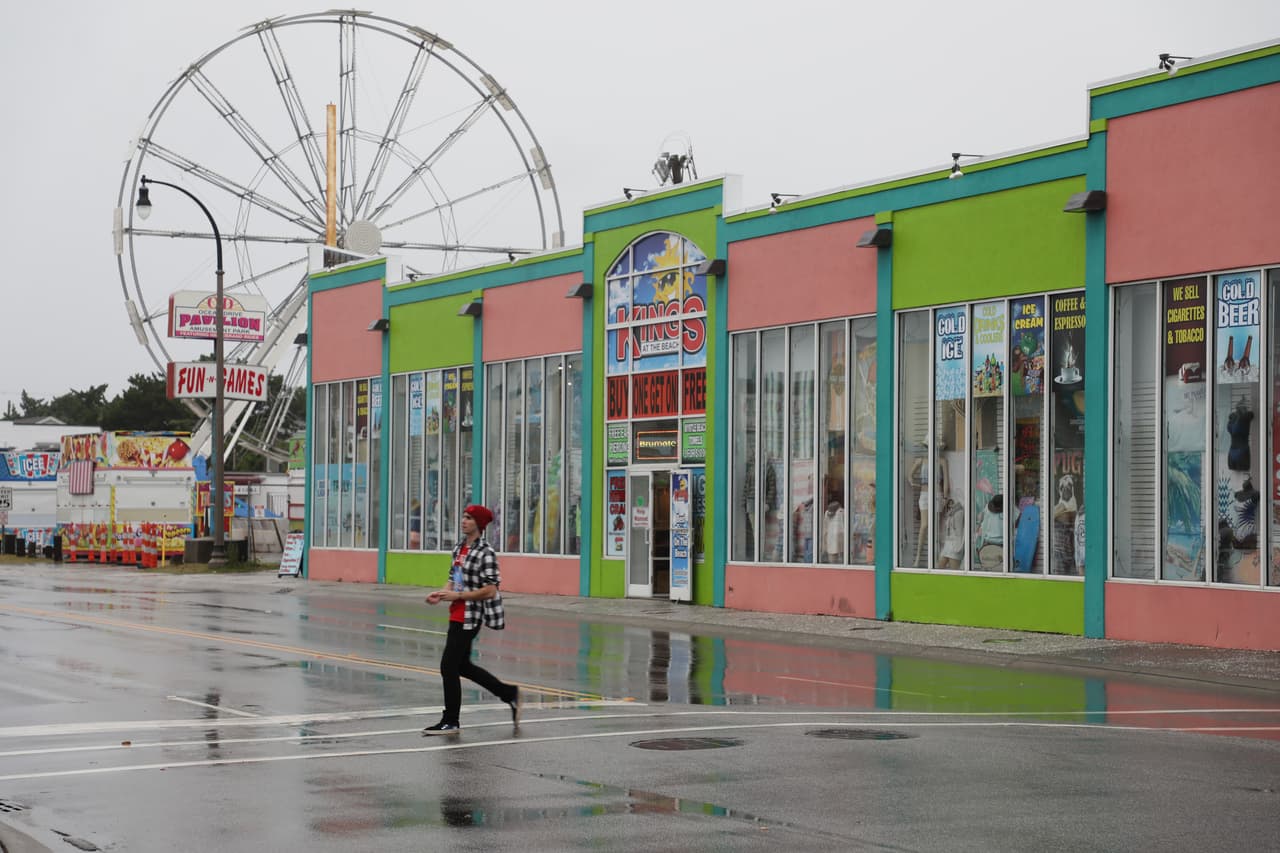 Un hombre cruza la calle en el centro de North Myrtle Beach mientras Isaías se acerca a la costa de Carolina del Sur, con fuerza de huracán y vientos máximos sostenidos de 85 millas por hora. Se esperan lluvias y fuertes vientos desde el este de las Carolinas hasta la costa del medio Atlántico.