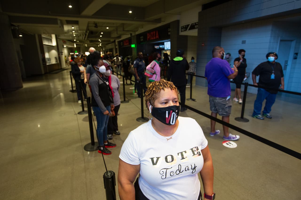 Heather King espera en la fila en State Farm Arena, el lugar de votación anticipada más grande de Georgia, para emitir su voto durante el primer día de votación anticipada en las elecciones generales el 12 de octubre de 2020 en Atlanta, Georgia.