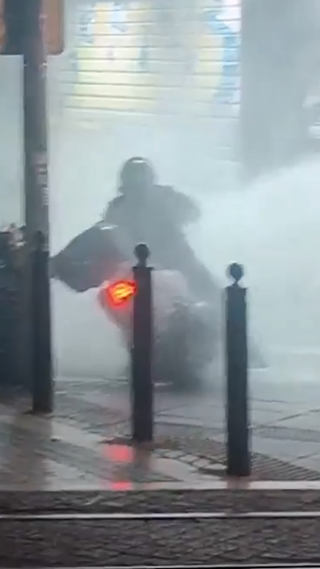 Un cañón de agua policial derriba a un motociclista
