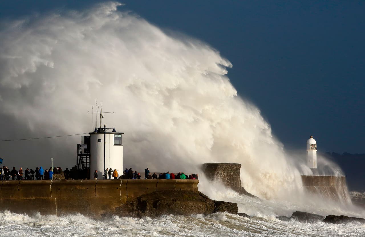 Enormes olas golpean al puerto y el faro de Porthcawl, en Gales. En Inglaterra y Escocia se han emitido advertencias de inundaciones y se esperan copiosas lluvias.