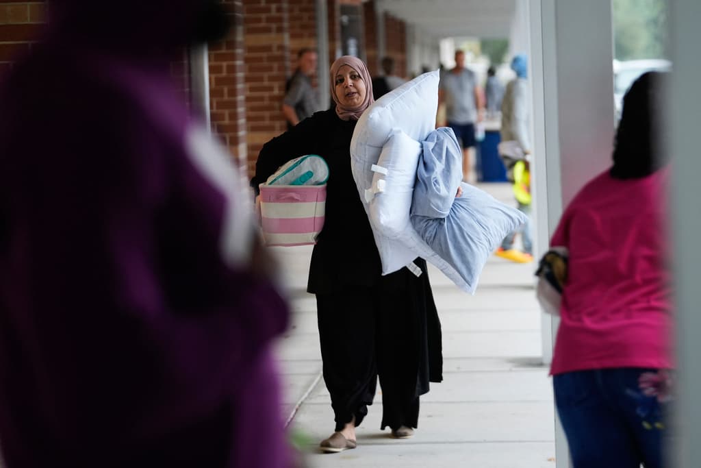 <b>Para estar cómoda: </b>Una mujer lleva almohadas y suministros a la escuela secundaria Gibbs, un refugio gubernamental contra tormentas donde 1,700 personas ya habían buscado refugio a última hora de la mañana, antes de la llegada del huracán Milton, en St. Petersburg, Florida, el miércoles 9 de octubre de 2024.