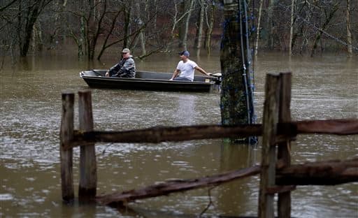 Dos hombres exploran en una barca una zona inundada junto a Copper Creed.