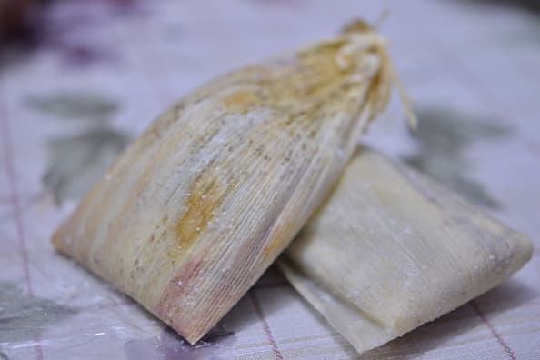 Se utiliza la hoja de maíz para envolver la masa que consta también de maíz.