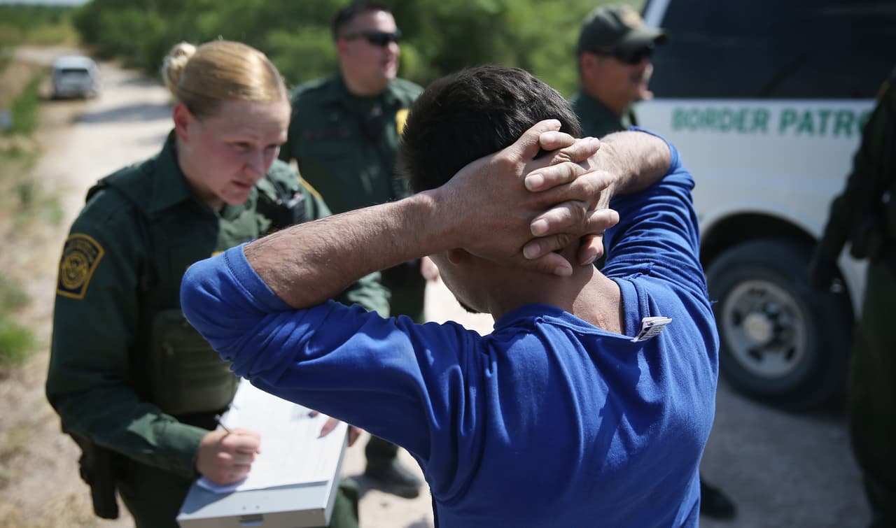 Un inmigrante indocumentado es detenido en un tramo de la frontera entre Texas y México por un agente de la Patrulla Fronteriza de Estados Unidos.