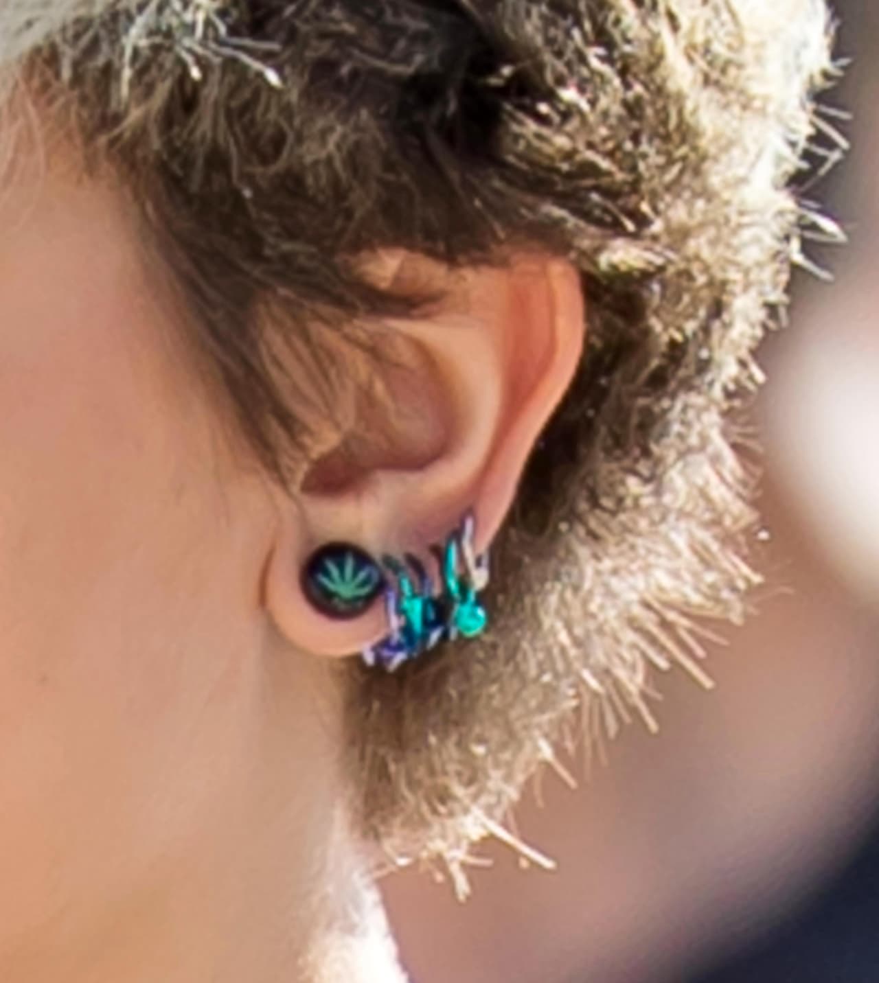 Sus aretes de mariguana y múltiples piercings.