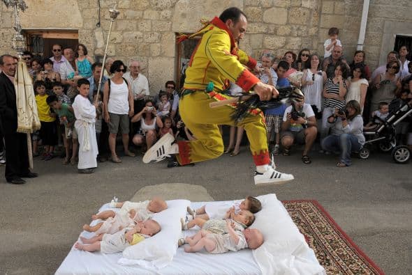 Ante el asombro y aplauso de cientos de espectadores este hombre salta por encima de estos bebés en Murcia, España.