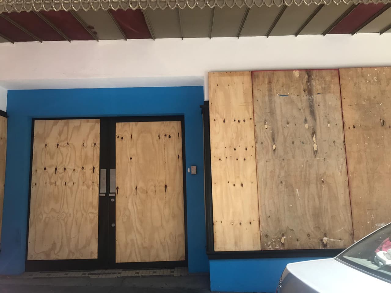 Un negocio en el viejo San Juan con madera contrachapada sobre sus ventanas y puerta