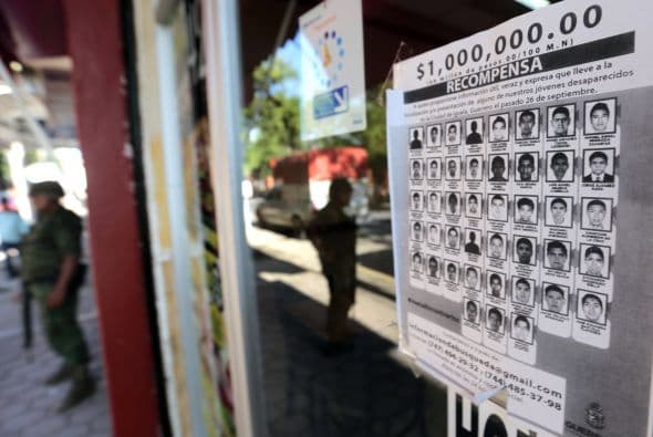 Un cartel con los retratos de los estudiantes desaparecidos se encuentra en exhibición en la entrada de una tienda en Iguala.