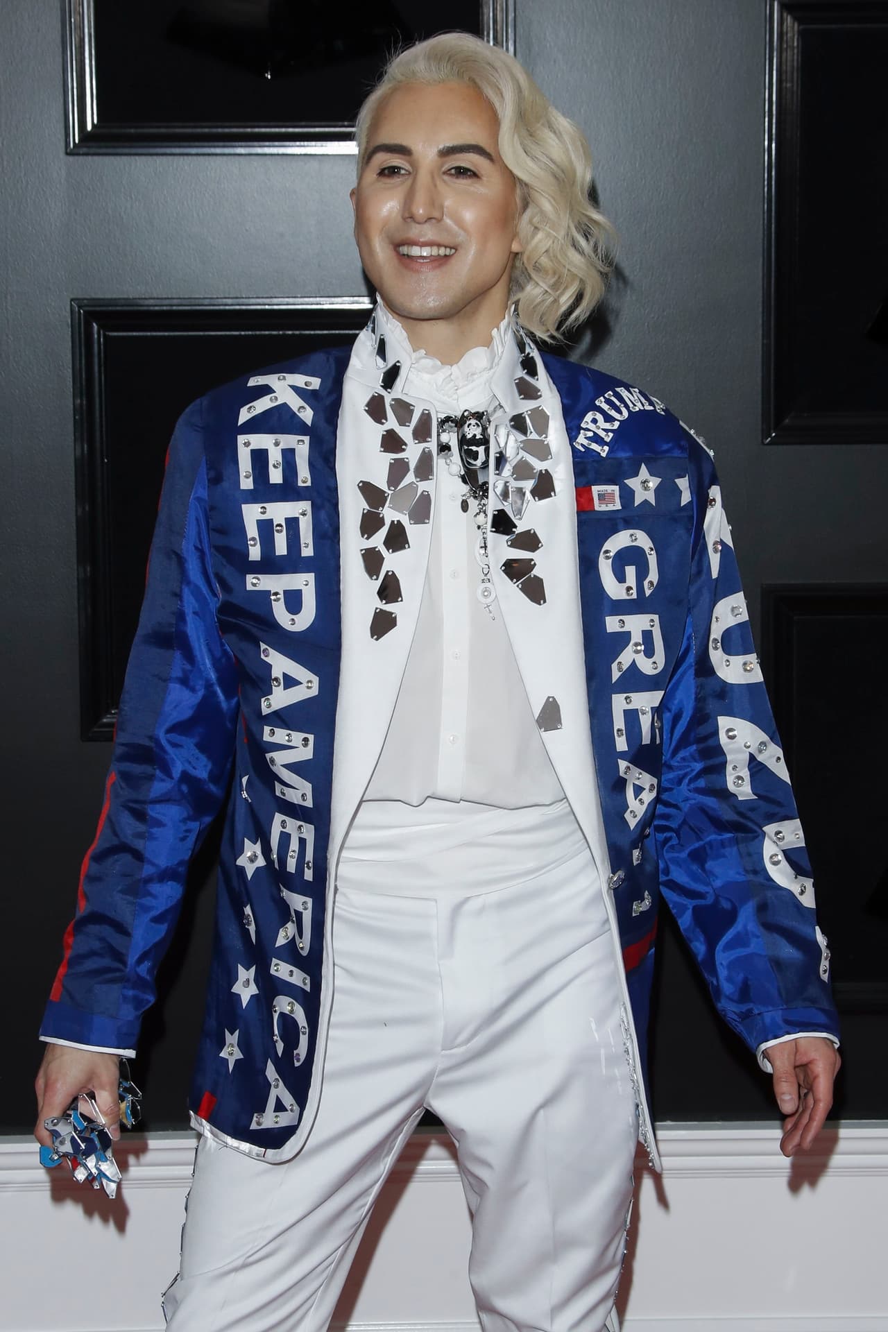 Villa no estuvo sola, por la alfombra de los GRAMMY este domingo 10 de febrero en el Staples Center de Los Ángeles también desfiló él cantante estadounidense Ricky Rebel, con un look pro-Trump.