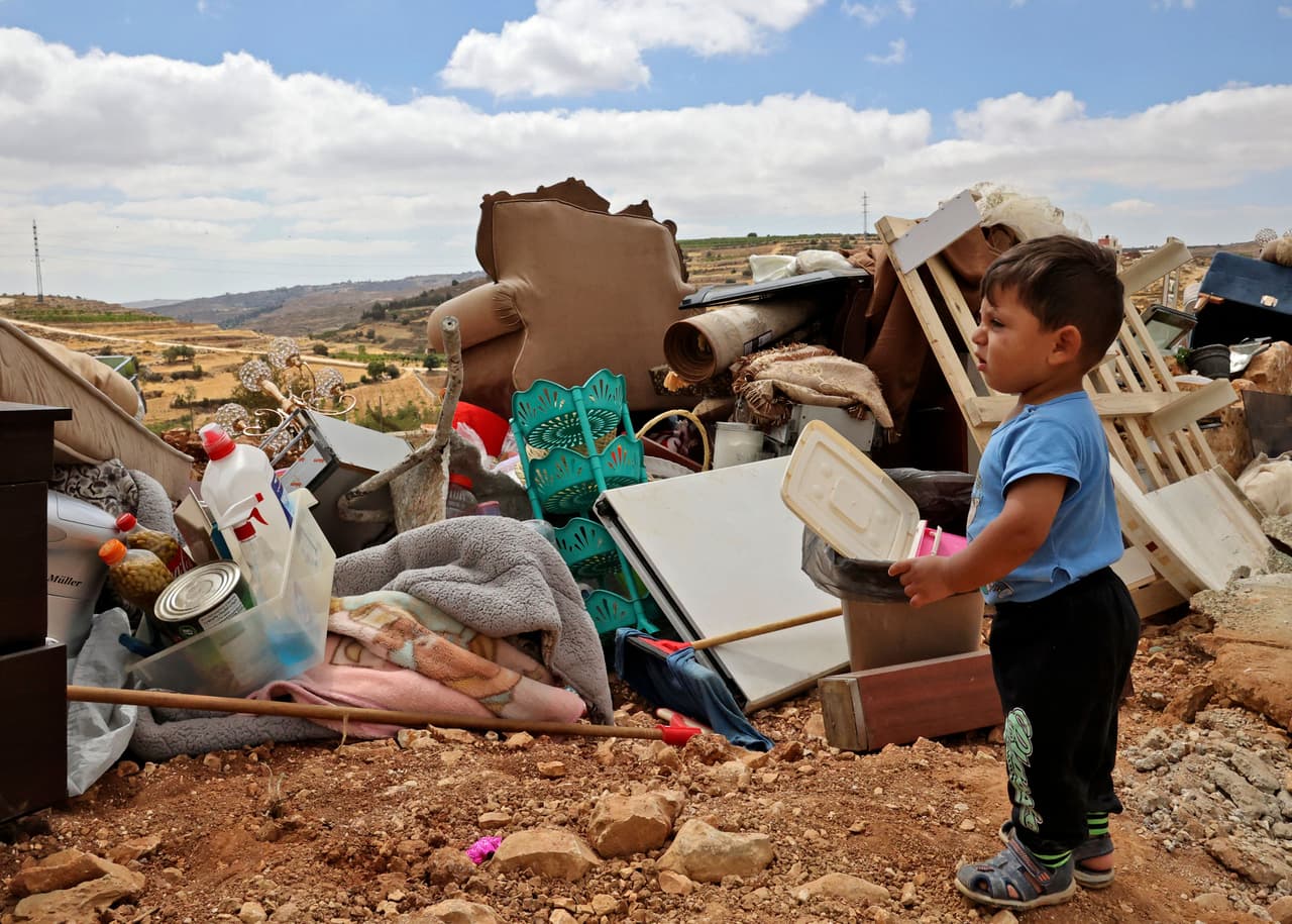 Un niño de una familia palestina revisa sus pertenencias después de que maquinaria israelí derribara su casa situada en la Cisjordania ocupada por Israel, donde Israel tiene control total sobre la planificación y la construcción, cerca de la aldea de Halhul (Halhoul), al norte de Hebrón, el 17 de junio de 2021.