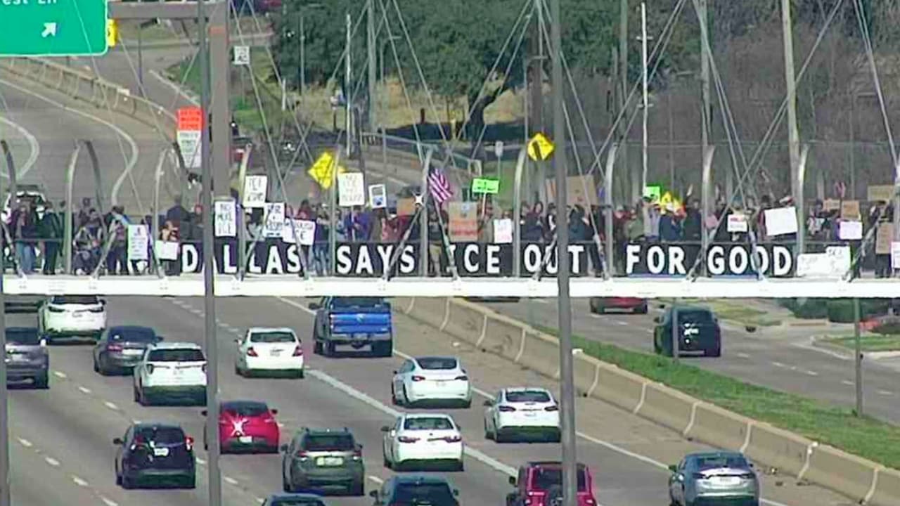 Activistas protestan contra ICE desde puente sobre la US 75 en Dallas.
