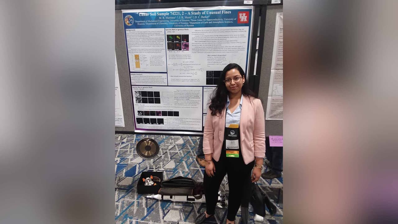 Mónica posa con un mapa de la luna sobre el sitio del alunizaje Apolo 17.