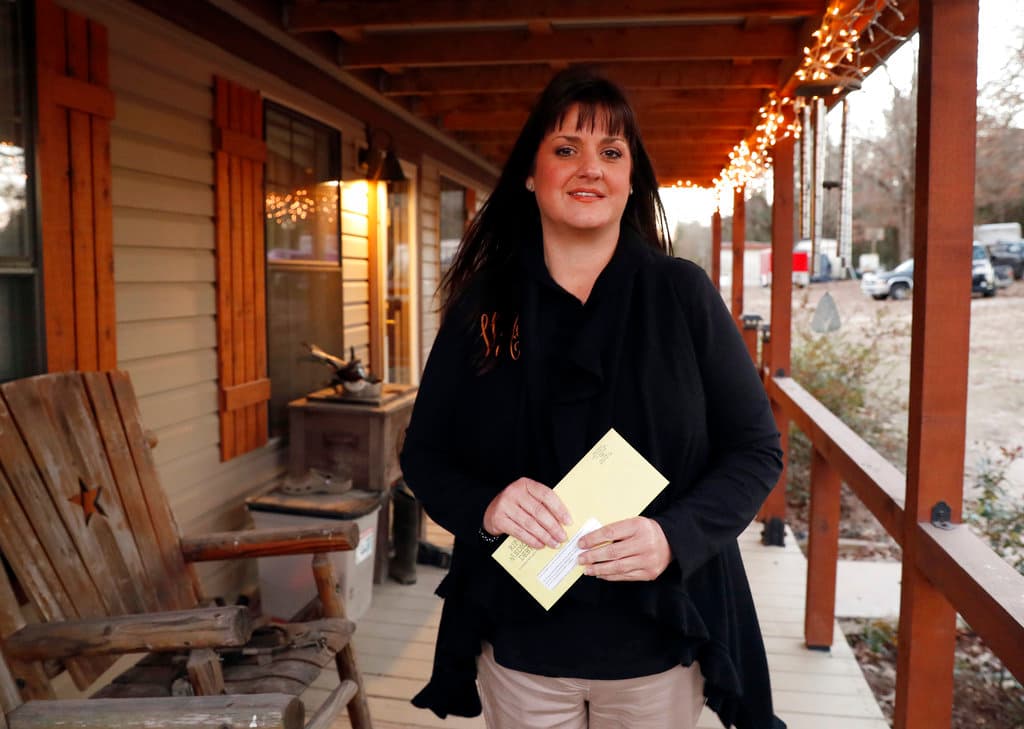 Reagen Adair con el sobre amarillo de RIP Medical Debt en su casa en Murchison, Texas, el pasado 20 de diciembre.