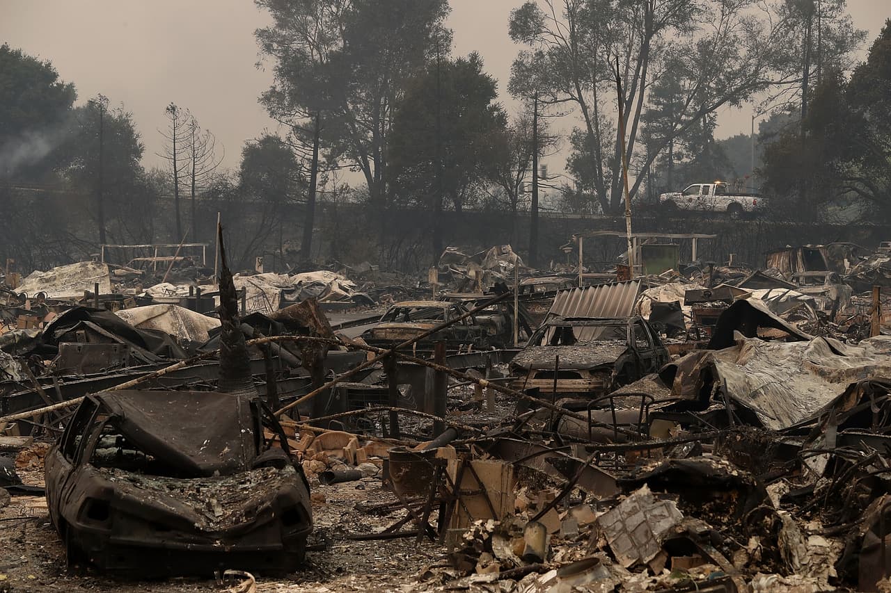 En esta imagen podemos ver 
<b>autos y casas rodantes reducidas a cenizas</b>. Las imágenes son de los incendios de octubre de 2016 en el norte de California en la zona de Napa y Sonoma. Este terreno era un parque de casas móviles y sus habitantes tuvieron que huir de la zona.