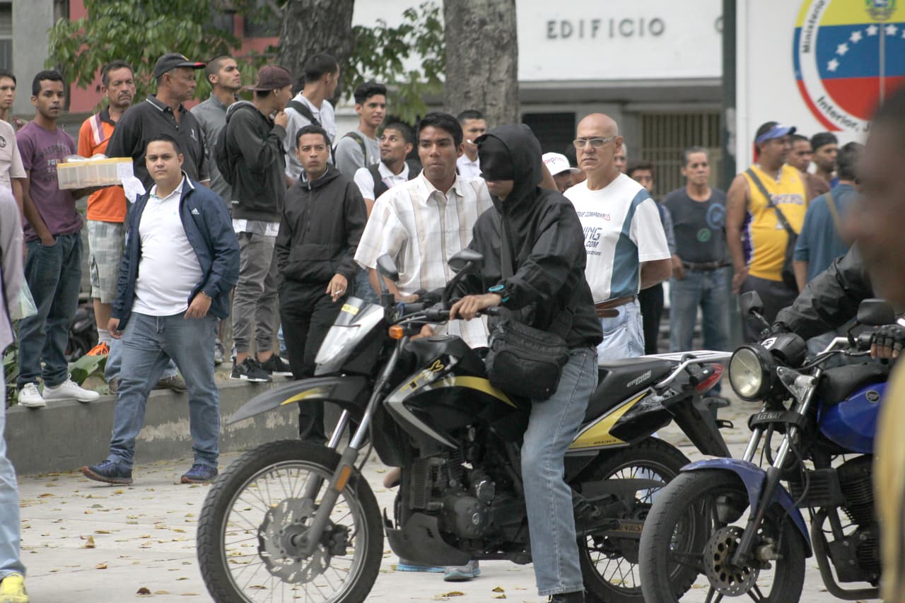 A bordo de motocicletas de alta cilindrada y empuñando armas de fuego, los 'colectivos' actúan como un factor disuasivo para ahogar el reclamo popular. Ejercen “dominio territorial” y han desplazado
<b> </b>a los cuerpos de seguridad regulares. En la imagen, un grupo disuelve una manifestación opositora en el centro de Caracas, 31 de marzo de 2017.