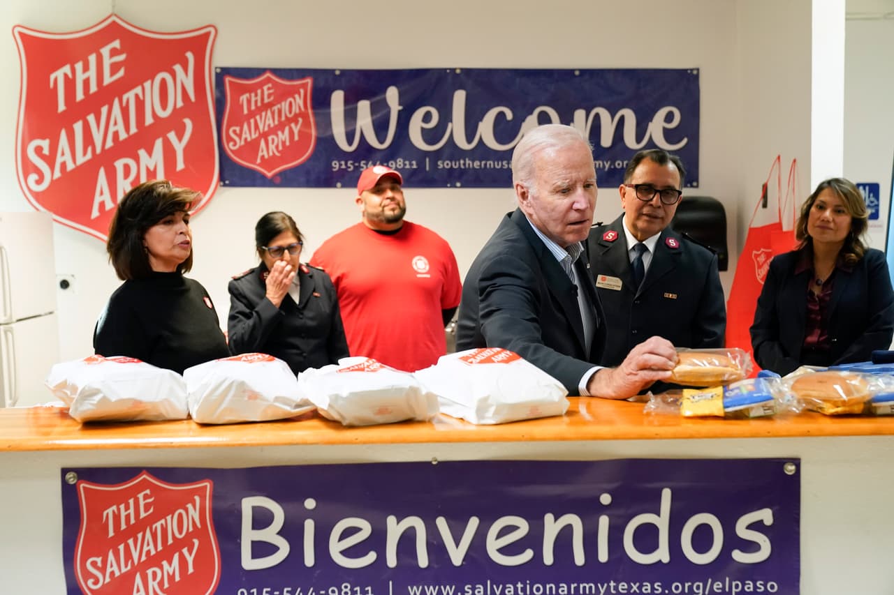 El presidente Joe Biden mira comida y otros artículos que se distribuyen a los inmigrantes refugiados durante su recorrido por el Centro para Apoyo de Inmigrantes del condado de El Paso (El Paso County Migrant Services Support Center). La congresista Verónica Escobar aparece a la derecha.
