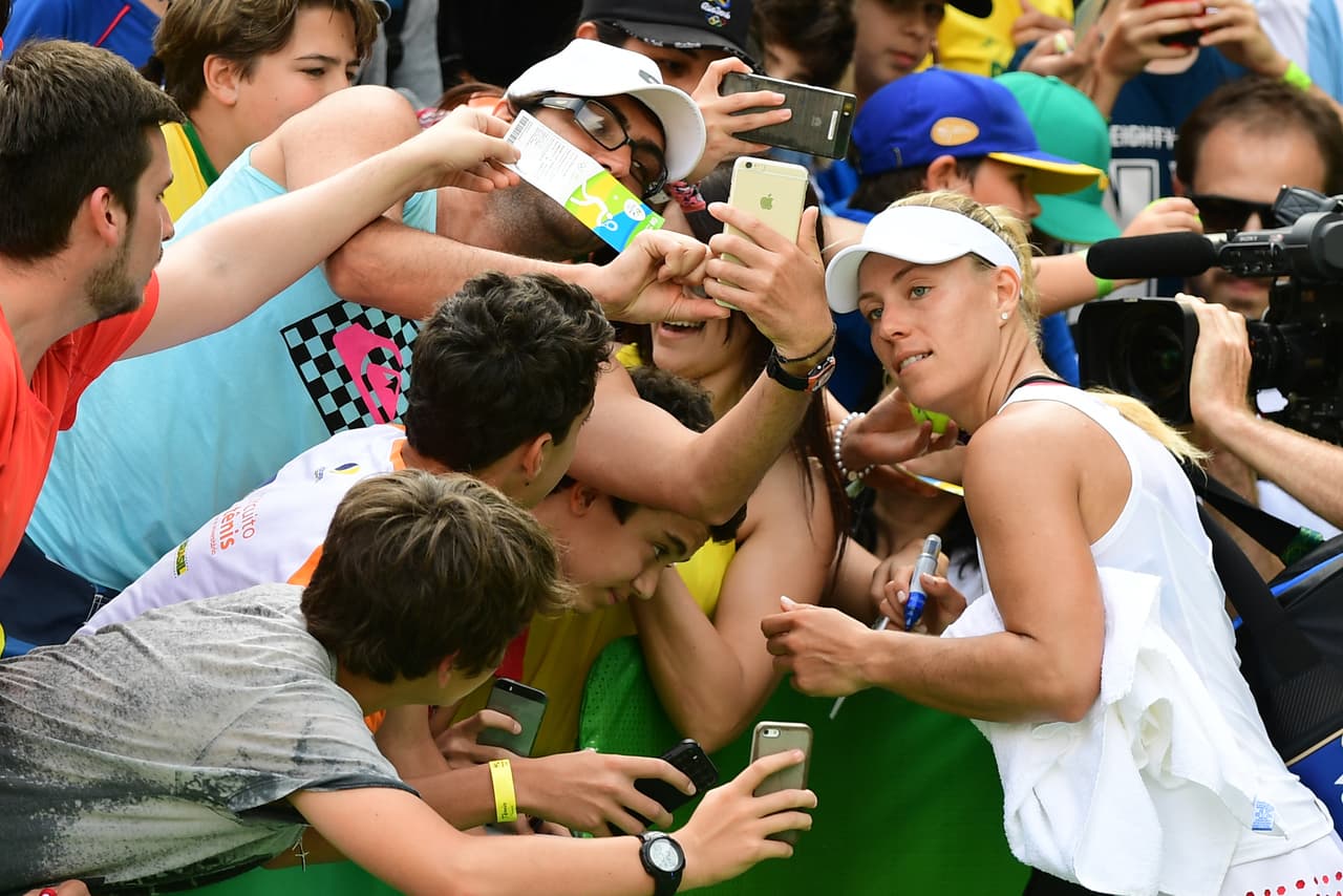 Queda muy claro que fanáticos y atletas no quieren quedarse fuera de la foto, aunque normalmente debes enfocar a la tenisa, amigo.