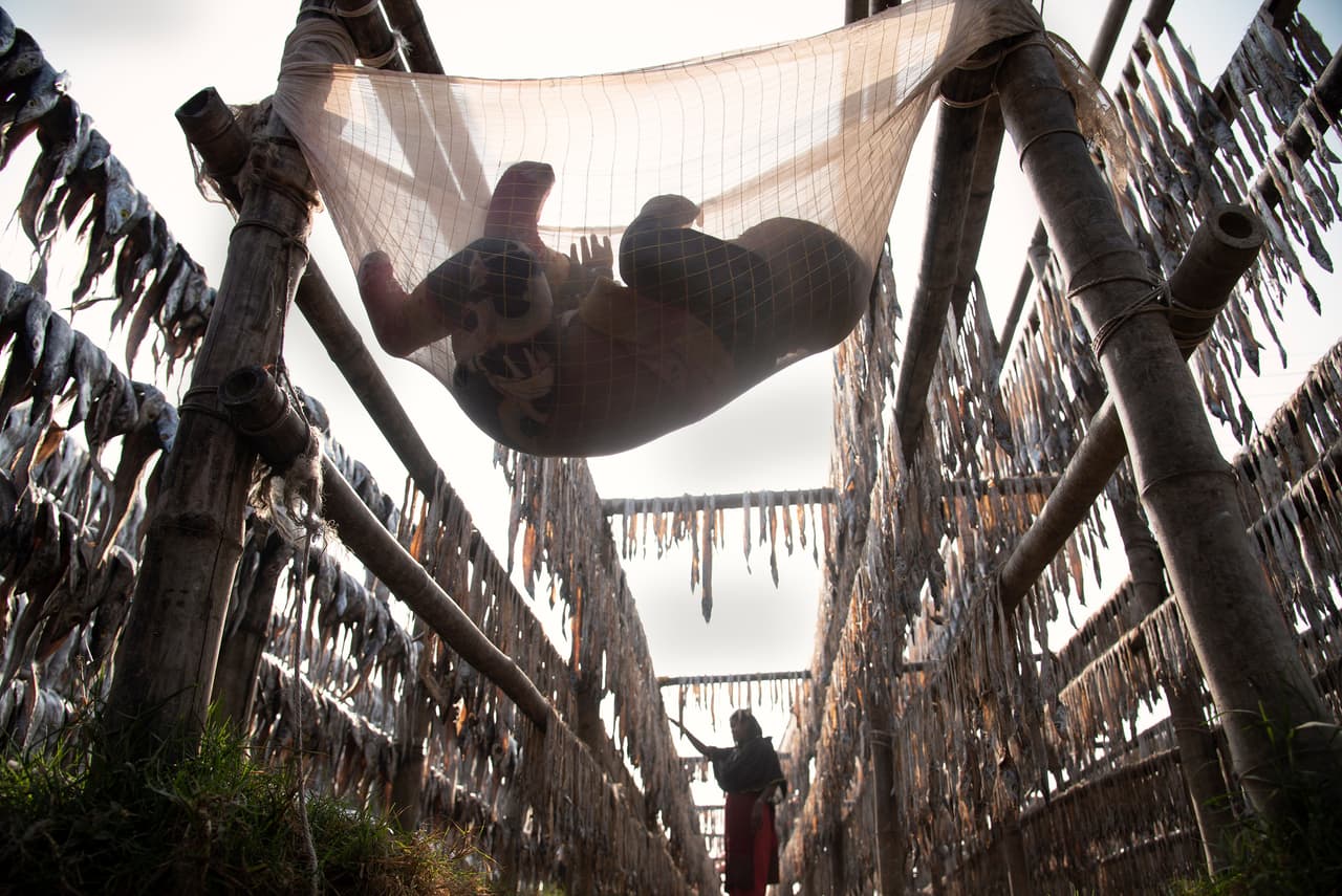 <b>‘Madre trabajadora’</b>
<br>
<br>Esta fotografía finalista muestra a una mujer trabajando en un área donde se secan pescados, mientras su hijo la espera.
<br>
<br>“Aunque todo el lugar está llenó de aire tóxico de pescado podrido y seco, la mujer debe continuar buscando el sustento de su familia”, explicó el concurso. “Además, debe cuidar a su hijo mientras cumple sus obligaciones laborales”.
<br>