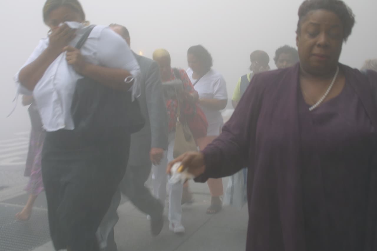 Trabajadores huyendo del World Trade Center. Inmediatamente después del primer choque de los aviones, policías, paramédicos y bomberos fueron enviados a la zona para asistir en las labores de emergencia.