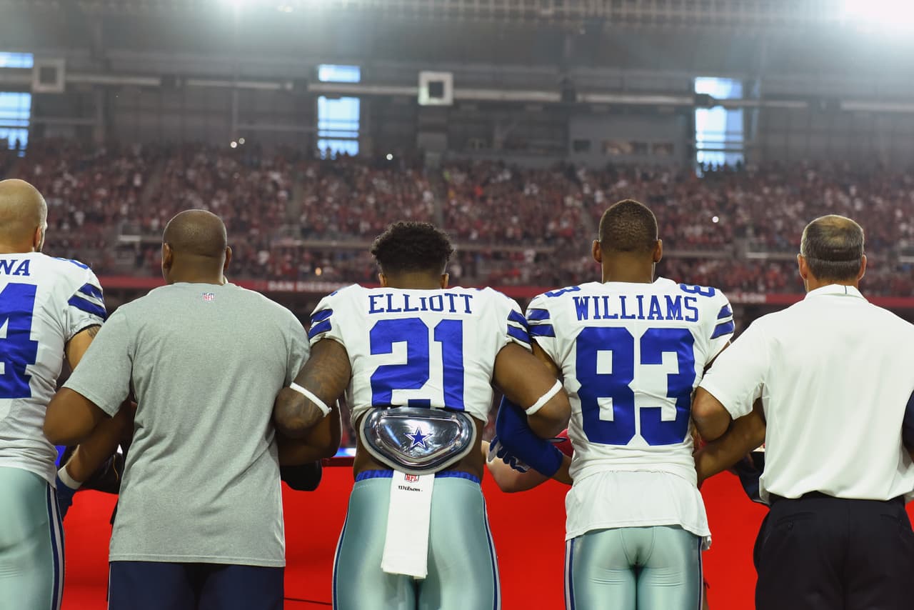 Dallas Cowboys y Arizona Cardinals con su respuesta ante el himno de los Estados Unidos en el University of Phoenix Stadium.