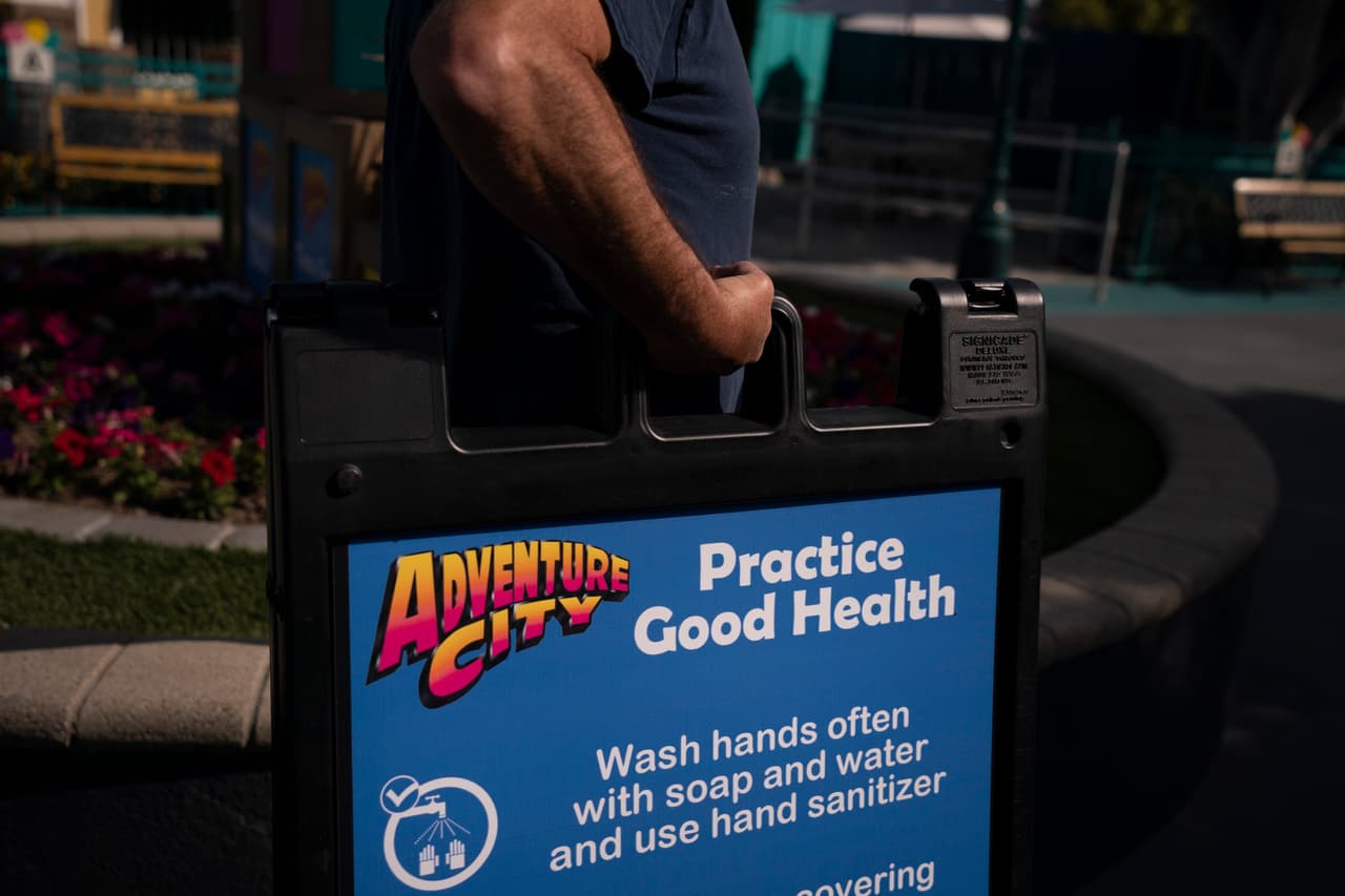 Allan Ansdell Jr., dueño del parque Adventure City, carga un letrero que invita a las personas que acudan al parque a respetar las medidas de restricción. "Son emociones encontradas", dijo. "Los parques de diversiones funcionan por temporadas. A veces puedes tener un mes de lluvias. Siempre teníamos lo suficiente para aguantar tres o cuatro meses de sabrá Dios qué. Pero nadie se preparó para un año. Ha sido difícil para todos nosotros", dijo Ansdell Jr., quien comentó que al inicio de la pandemia tuvo que despedir a la mayoría de sus 150 empleados. "Ha sido muy difícil para nosotros. Me da gusto que estemos pasando esta etapa".