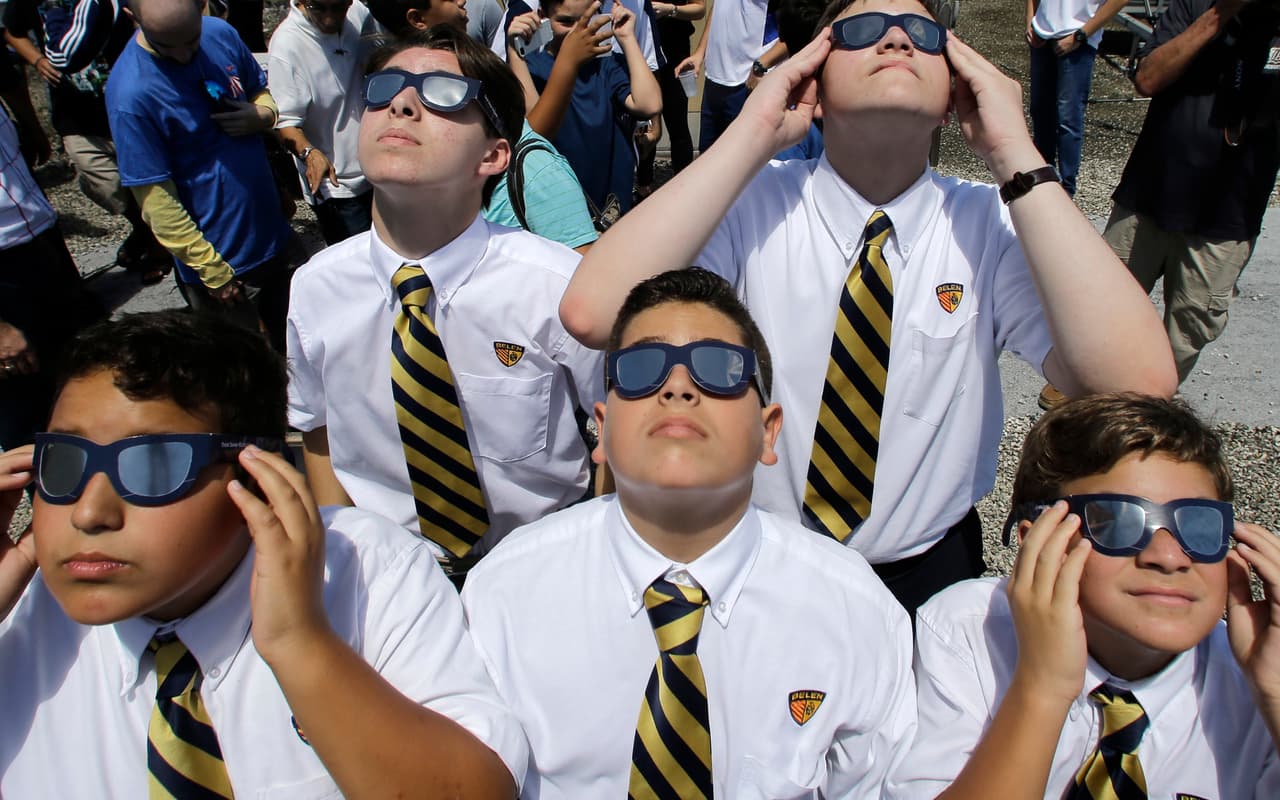 Los Niños de la escuela preparatoria Belén de Miami, FLorida, miran el fenómeno con sus gafas especiales.