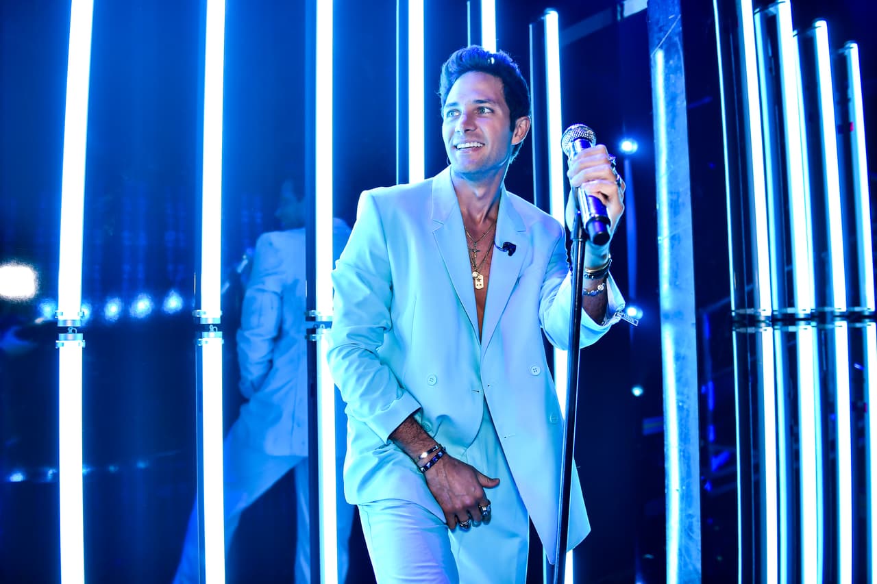 El actor y cantante venezolano subió al escenario con un traje casual en tono celeste, el que llevó sin camisa, tan solo con algunos accesorios que resaltaban en su pecho.