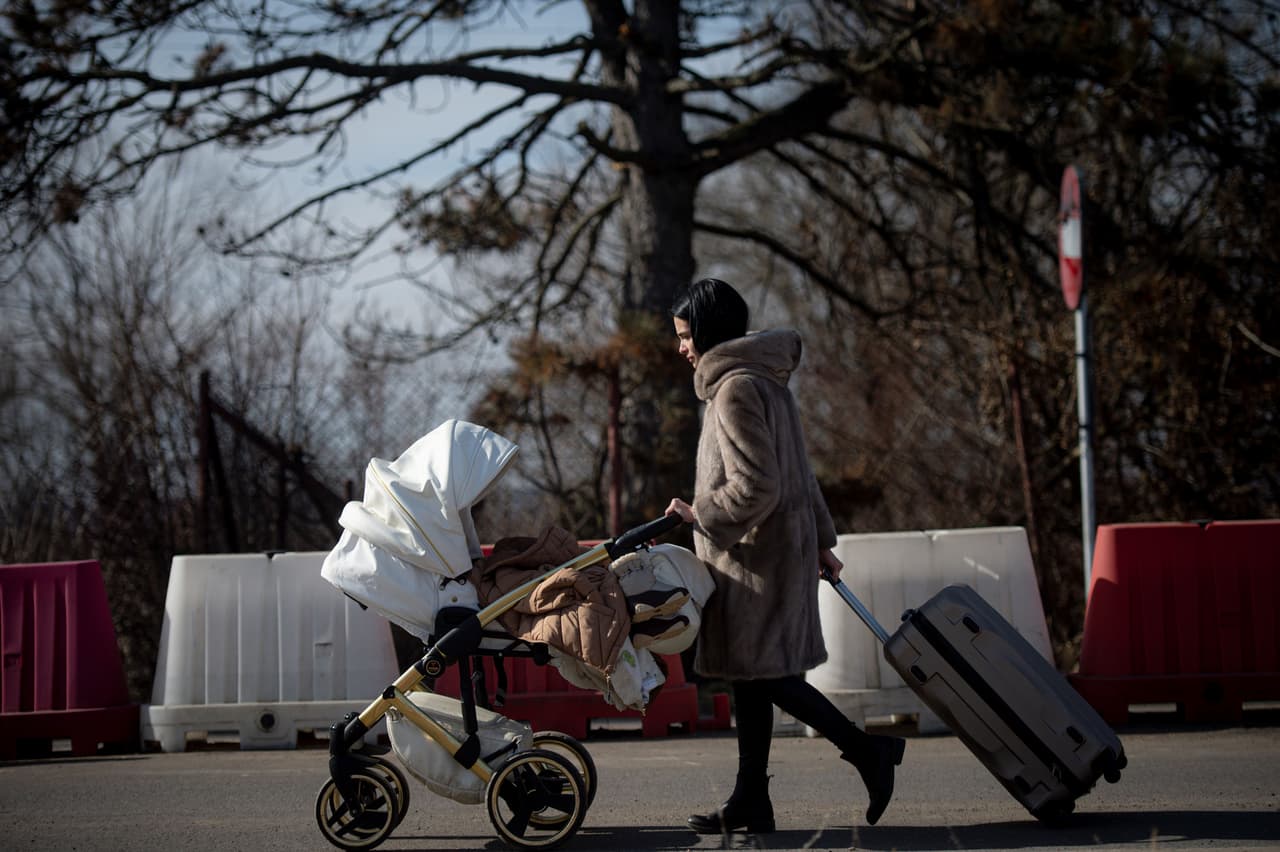 Una mujer empuja un cochecito de bebé después de cruzar la frontera desde Ucrania hacia Siret, Rumania, el 25 de febrero. El Gobierno rumano eliminó las restricciones por covid-19 para todas las personas que entren a su territorio procedentes de Ucrania, luego que miles de ucranianos solicitaron refugio en Rumanía luego de la invasión rusa.
<br>