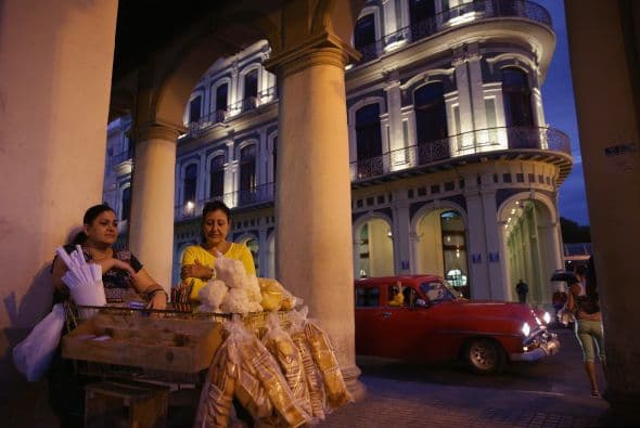 Una vendedora ofrece galletas, chicles y otros aperitivos envasados en el barrio de la Habana Vieja.