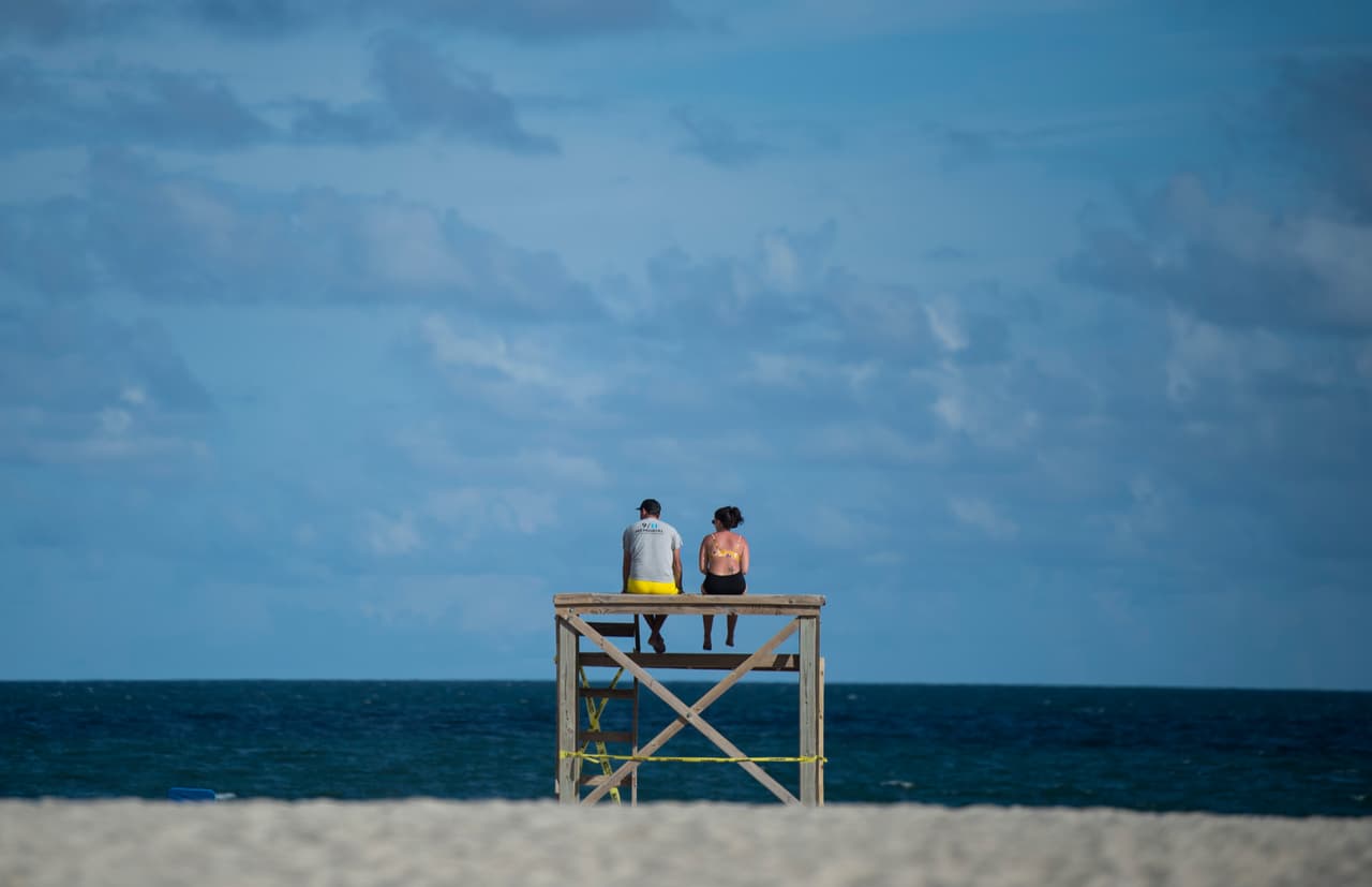 Dos personas miran el océano todavía calmado en Wrightsville Beach, Carolina del Norte. Florence avanza a 16 millas por hora (26 kilómetros por hora) y el lugar donde tocará tierra aún no es precisado por los expertos.