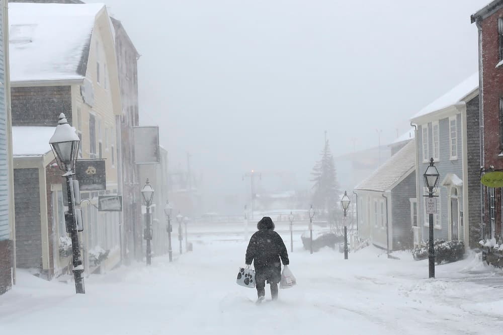 Una mujer anda bajo la nieve en New Bedford, en Massachusetts