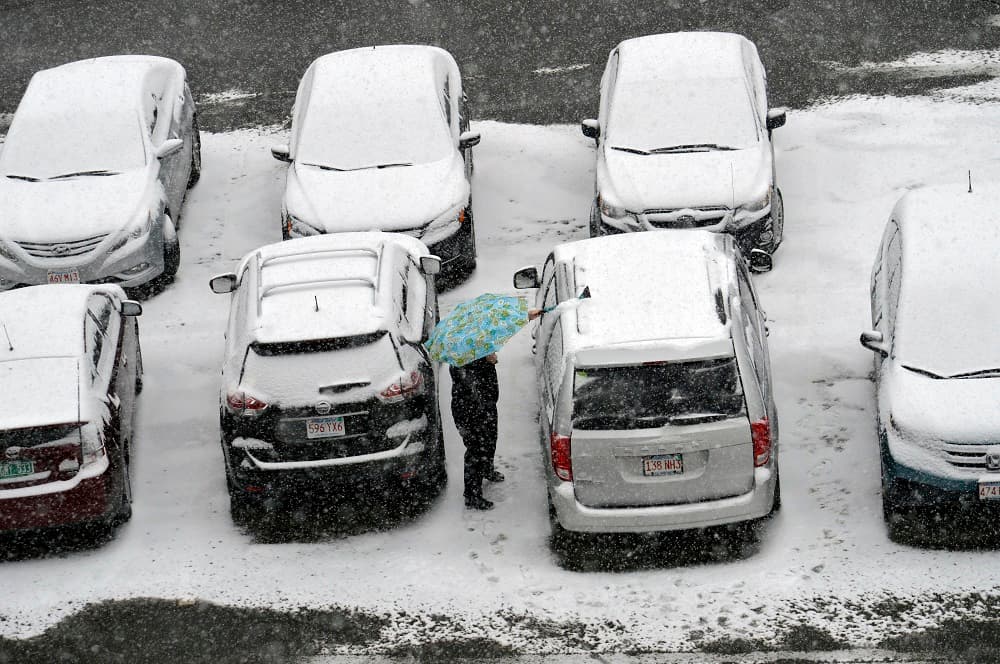 Una mujer trata de limpiar la nieve acumulada en un carro en Pittsfield, en Massachusetts.