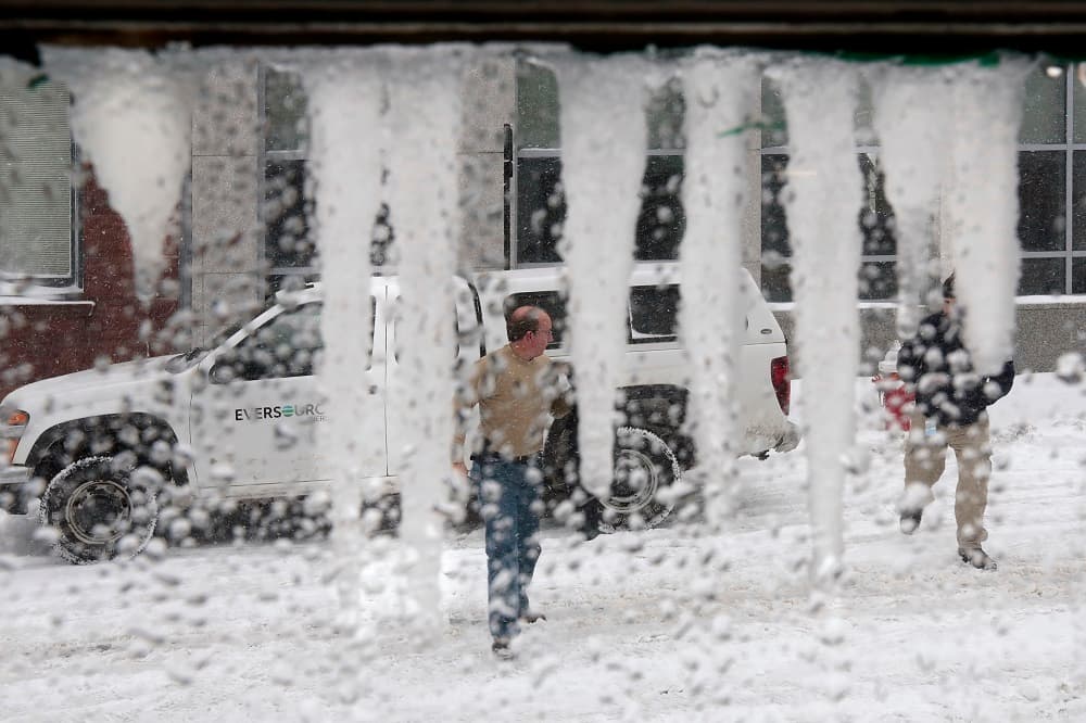 Dos personas cruzan una calle frente a una vitrina congelada en un café en New Bedford, Massachusetts.