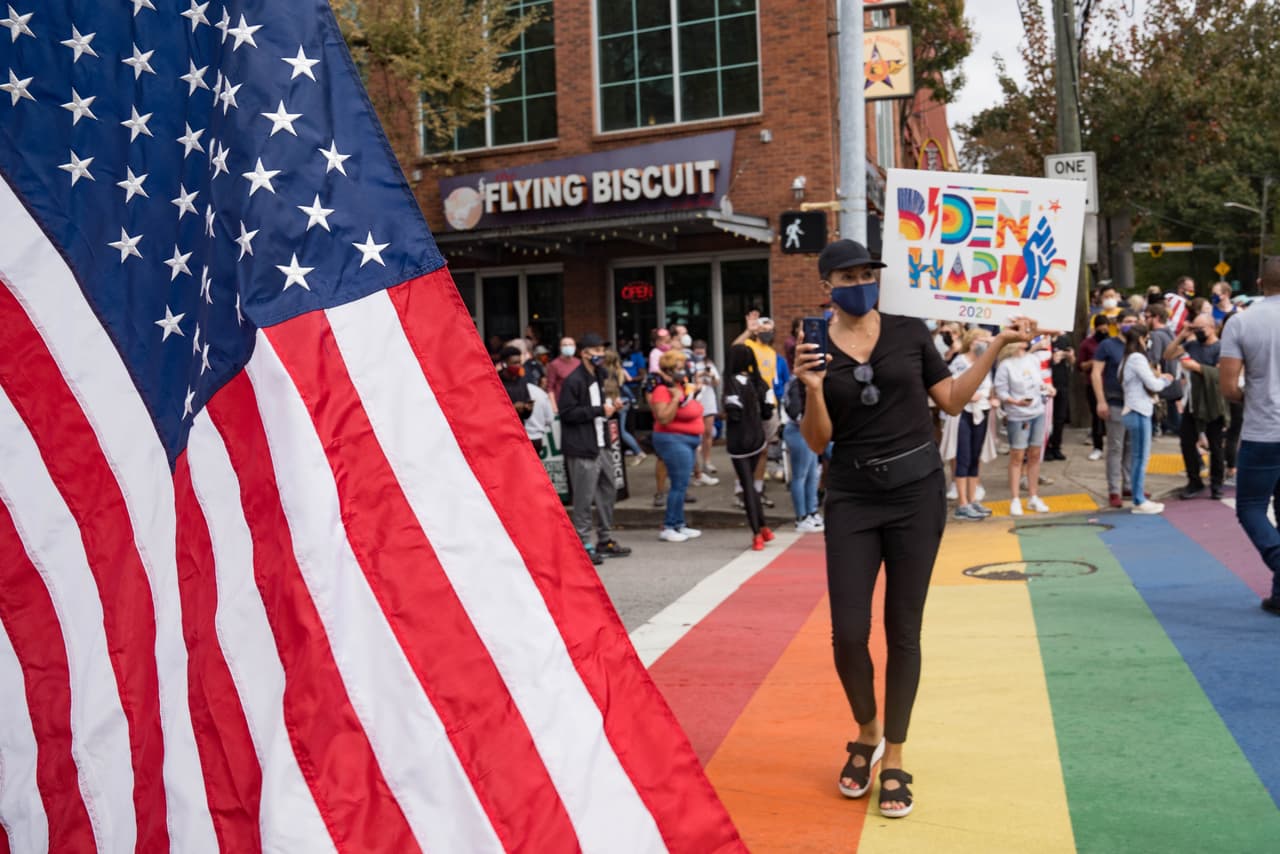 Carteles y banderas pintaron las calles y el ambiente en esta área de Atlanta luego del anuncio del triunfo de Joe Biden.