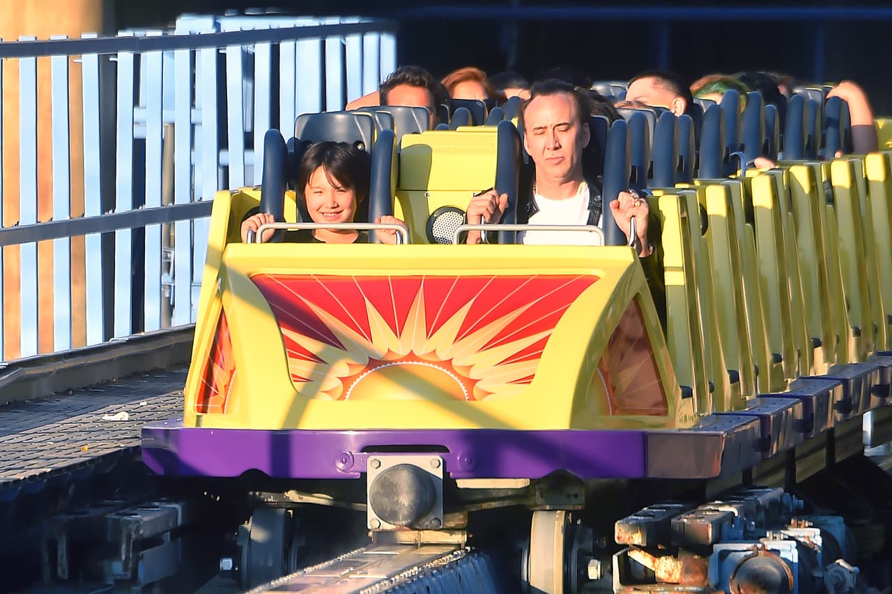 Padre e hijo estaban emocionadísimos por subir a una montaña rusa.