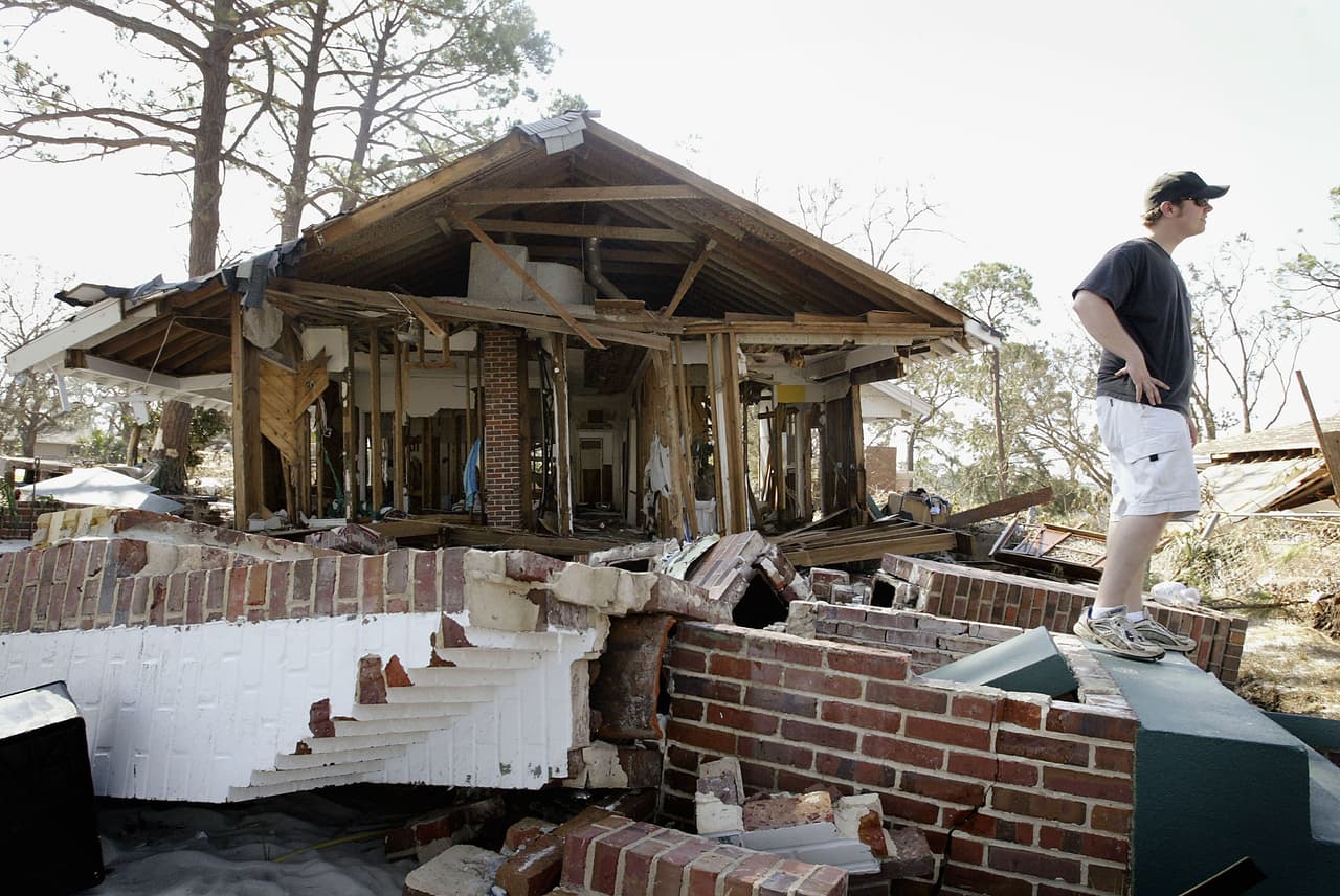 PENSACOLA, FL - SEPTEMBER 18: Allen Farr surveys the wreckage of a friend's home left in the aftermath of Hurricane Ivan September 18, 2004 in Pensacola, Florida. Residents of the hurricane affected area are slowly beginning to return to their homes to asses the damage and begin recovery. Ivan came ashore near the Florida and Alabama State line causing several deaths and massive property damage in Alabama, Florida, Mississippi and Louisiana. (Photo by Scott Olson/Getty Images)